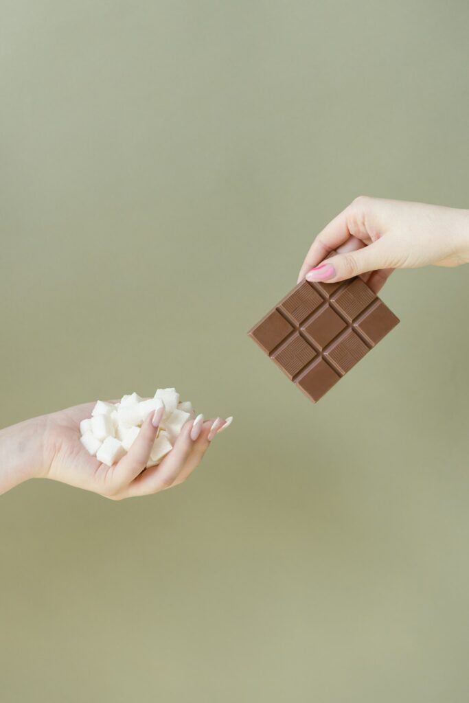 Zwei Hände mit Schokolade, Sahne & Zucker