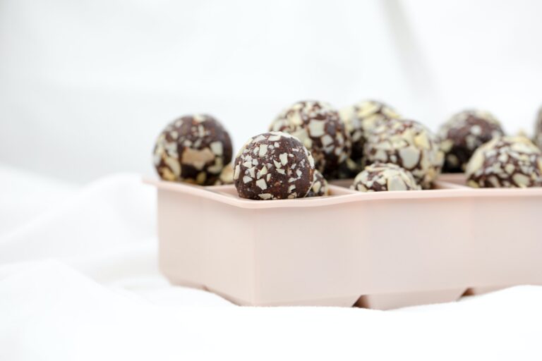 Energy balls sind wahre Energybomben. Sie enthalten viele Vitamine, Nährstoffe und Eisen. Auf dem Bild sieht man dunkelbraune Energiebälle, die selbstgemacht wurden. Es gibt einfache Rezepte mit und ohne Datteln, die umkompliziert und schnell umgesetzt werden können. Energiekugeln enthalten auch sehr viel Eisen für eine schöne Haut und Haare. Eisen ist wichtig gegen Haarausfall
